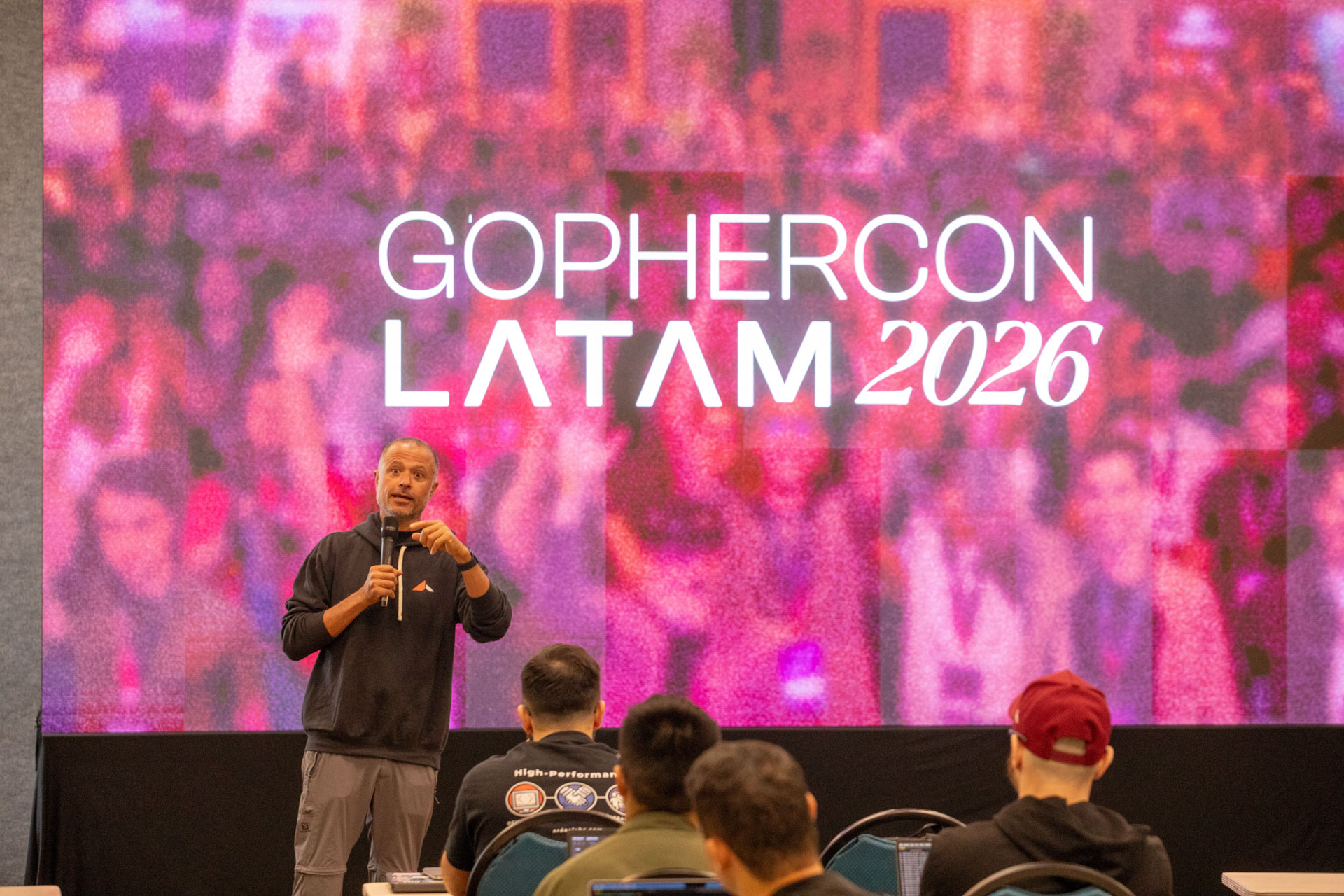 GopherCon LATAM 2026 — MJ welcoming attendees in front of the event title screen.