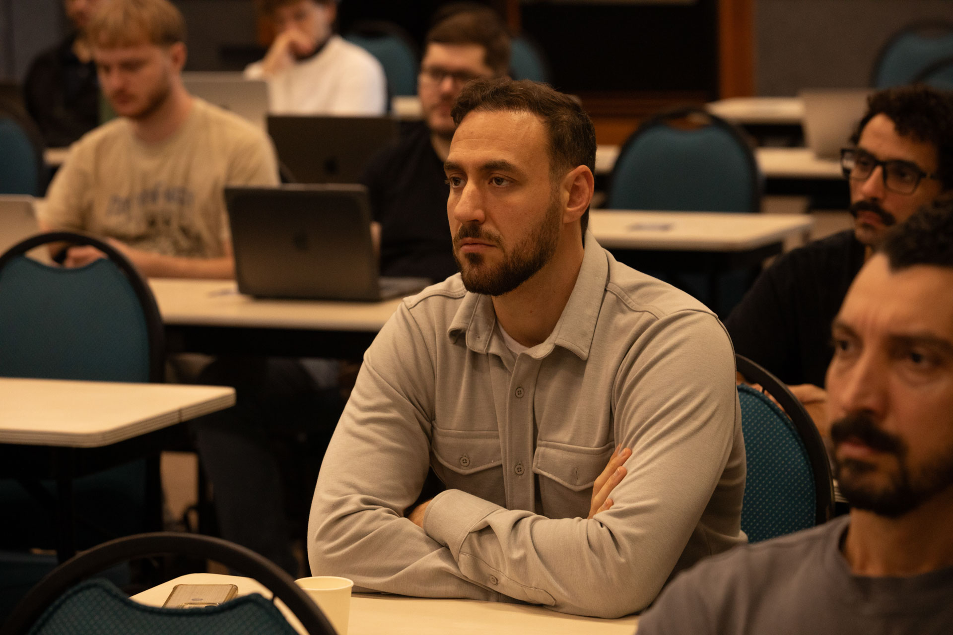 GopherCon LATAM 2026 — an attendee listening with arms folded during a talk.