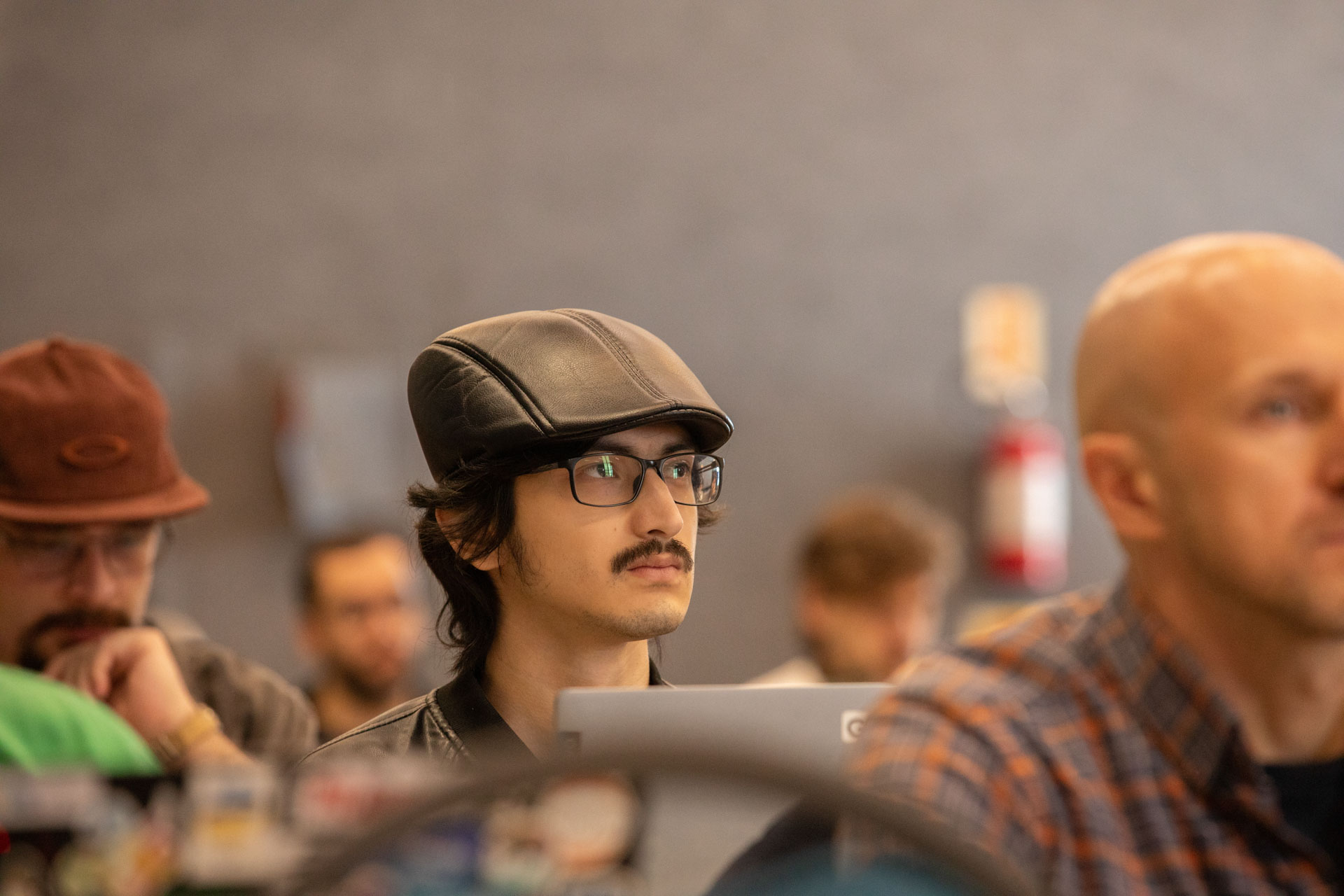 GopherCon LATAM 2026 — an attendee in a flat cap watching the presentation.