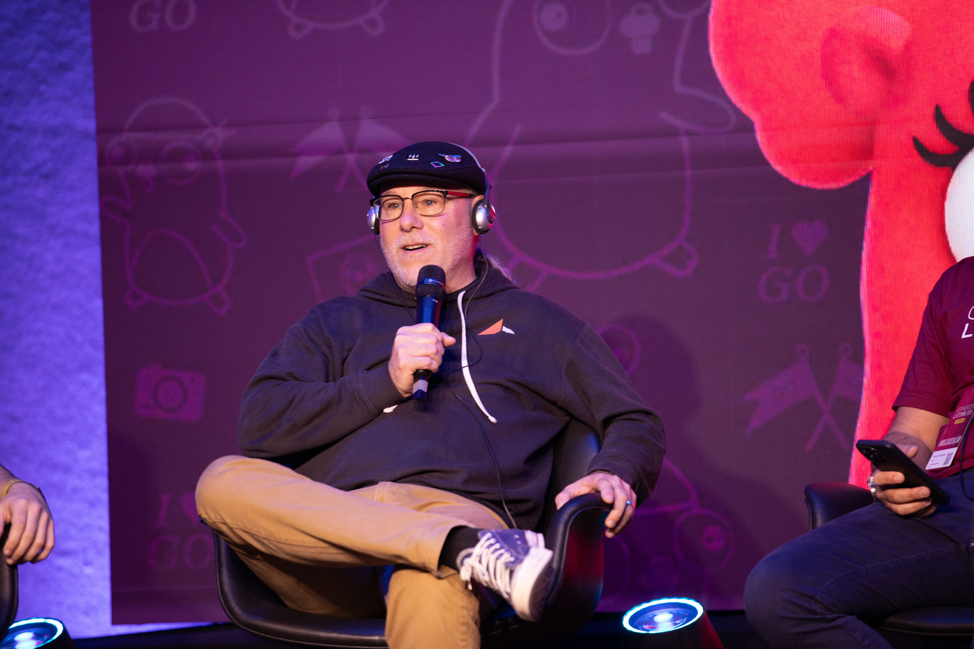 GopherCon LATAM 2026 — Bill Kennedy answering a panel question beside the event mascot.