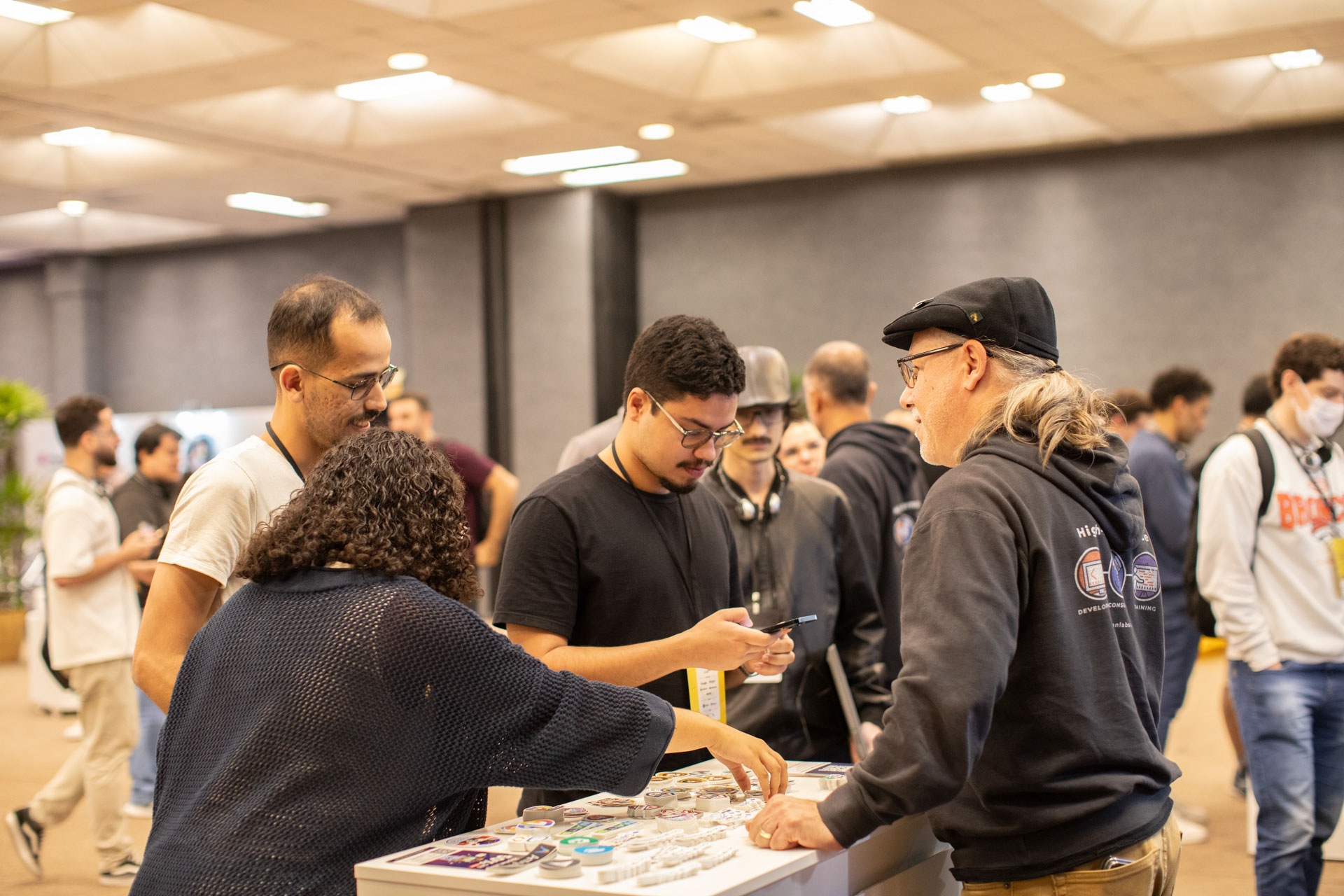 GopherCon LATAM 2026 — Bill Kennedy handing out stickers and swag to attendees.