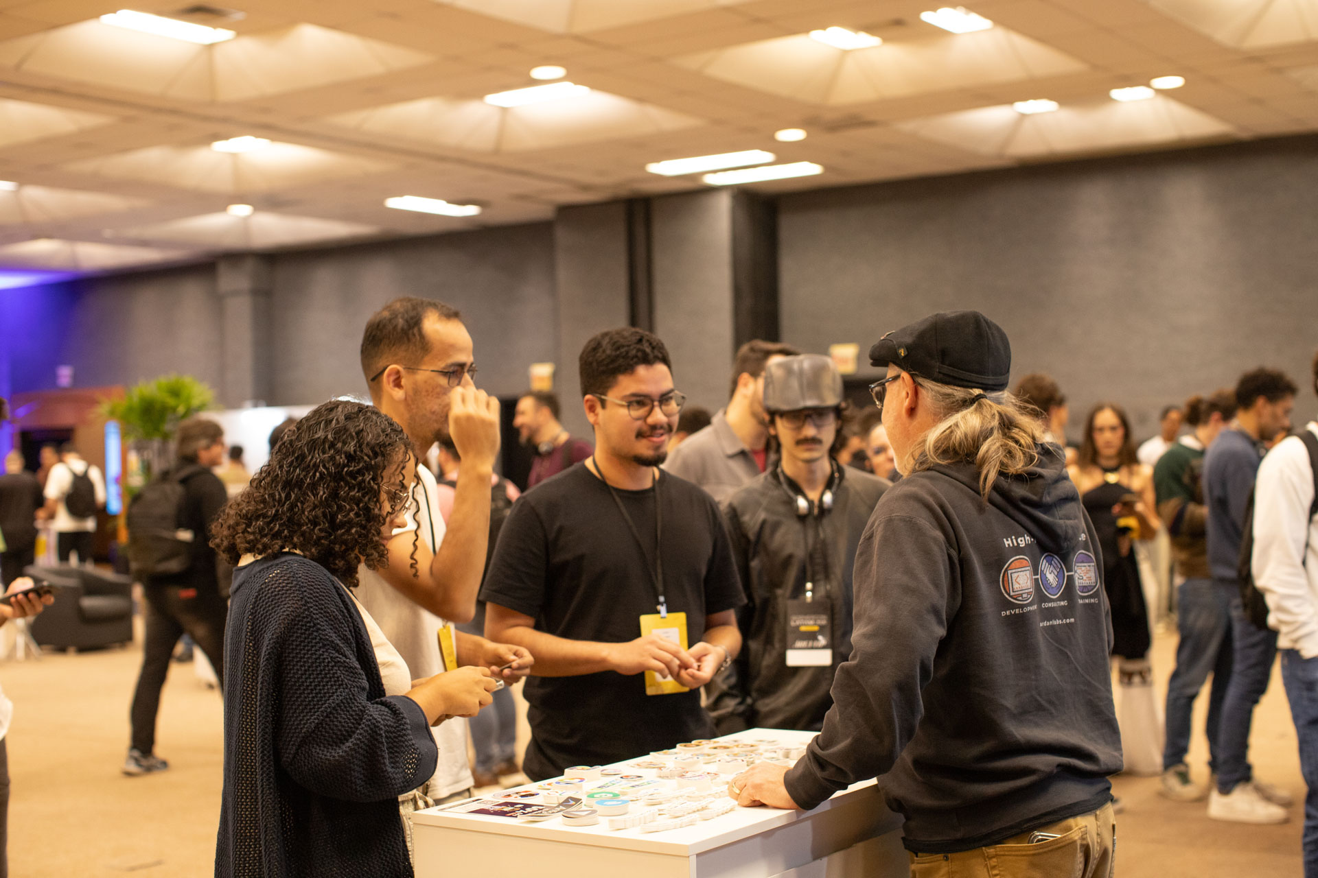 GopherCon LATAM 2026 — Bill Kennedy talking with Gophers at the Ardan Labs swag table.
