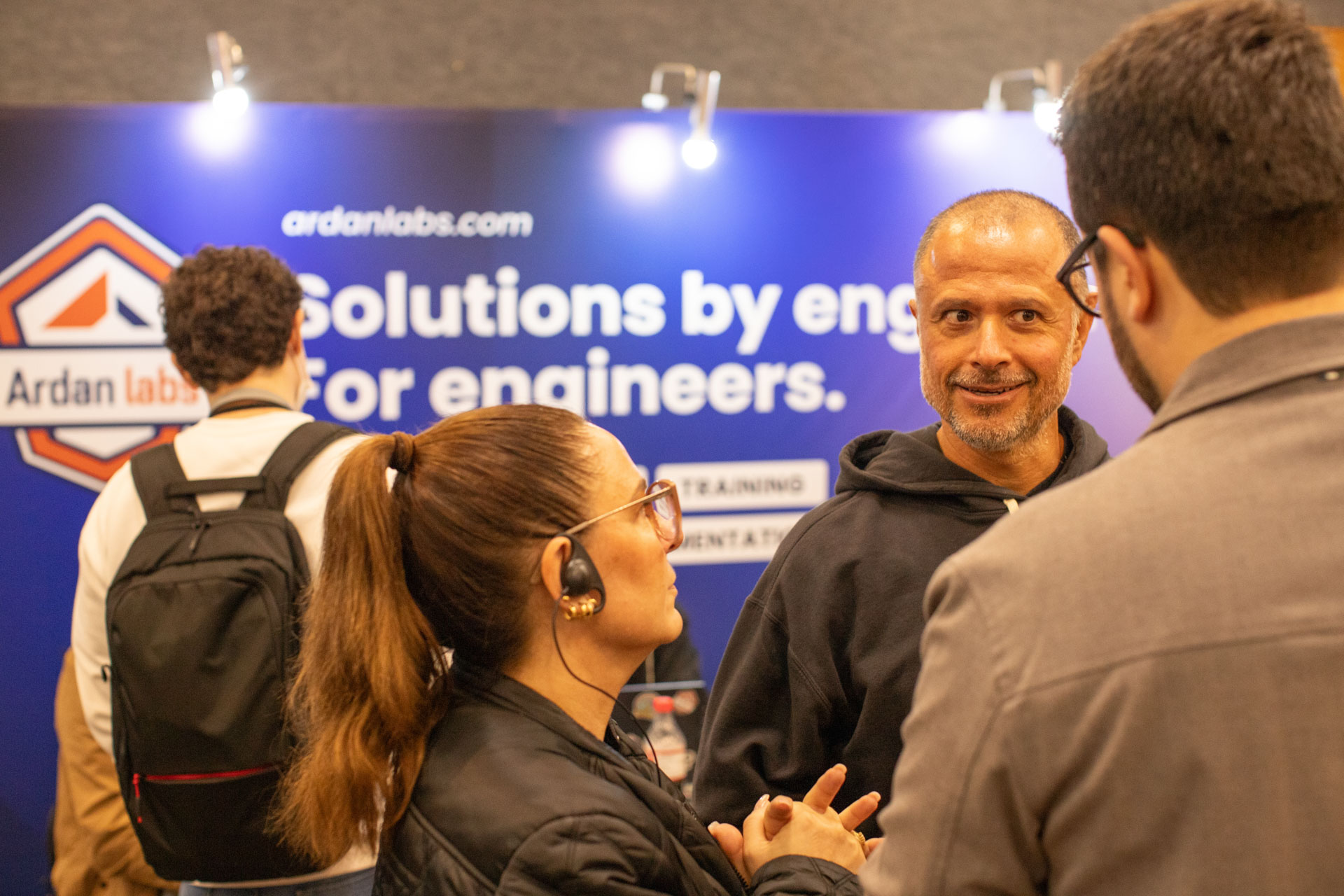 GopherCon LATAM 2026 — MJ in conversation with attendees in front of the Ardan Labs backdrop.