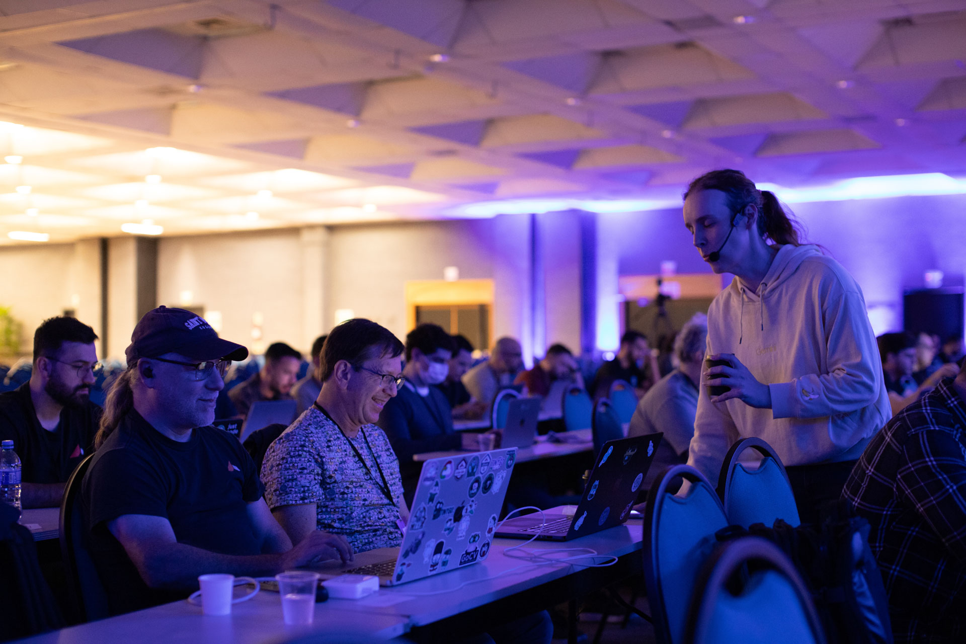 GopherCon LATAM 2026 — Bill Kennedy sharing a laugh with an attendee in the ballroom.