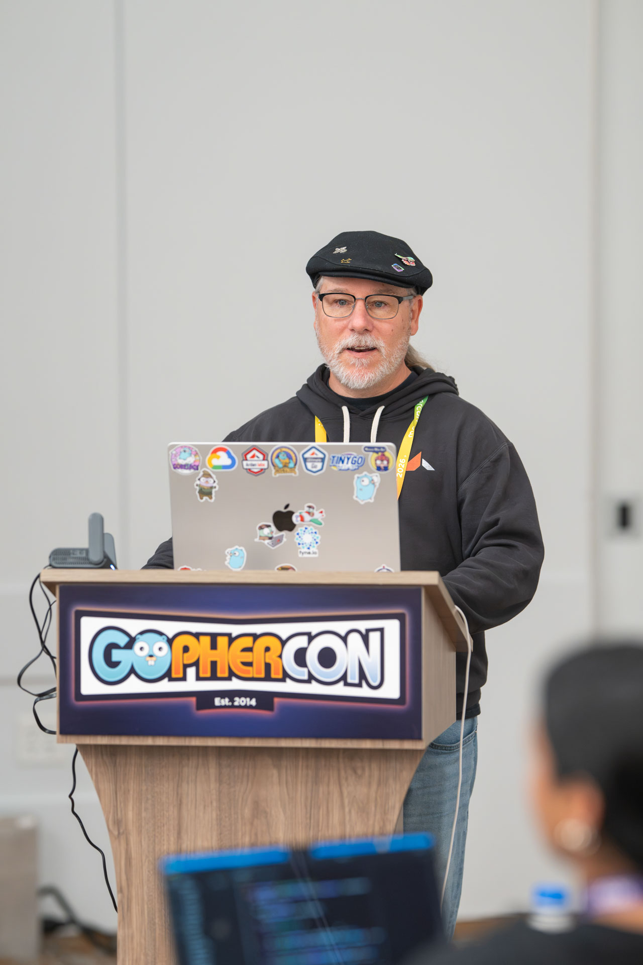 GopherCon US 2026 — Bill Kennedy at the GopherCon podium with his sticker-covered laptop.