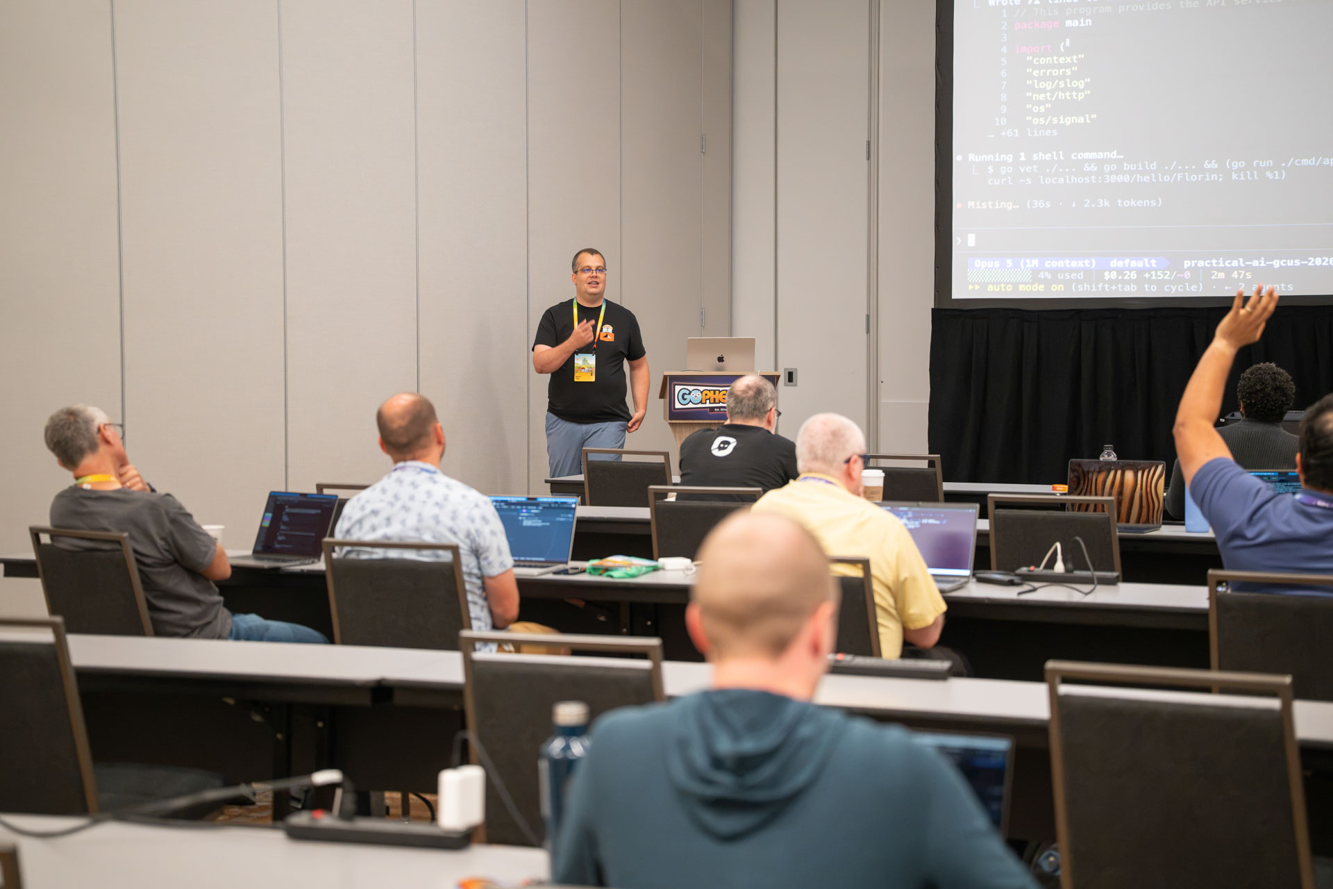 GopherCon US 2026 — an attendee raising a hand during Florin Pățan's live coding session.