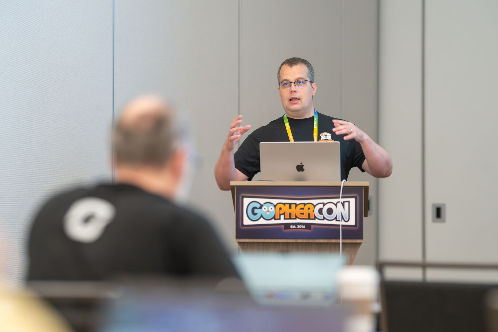 GopherCon US 2026 — Florin Pățan explaining a concept at the podium.