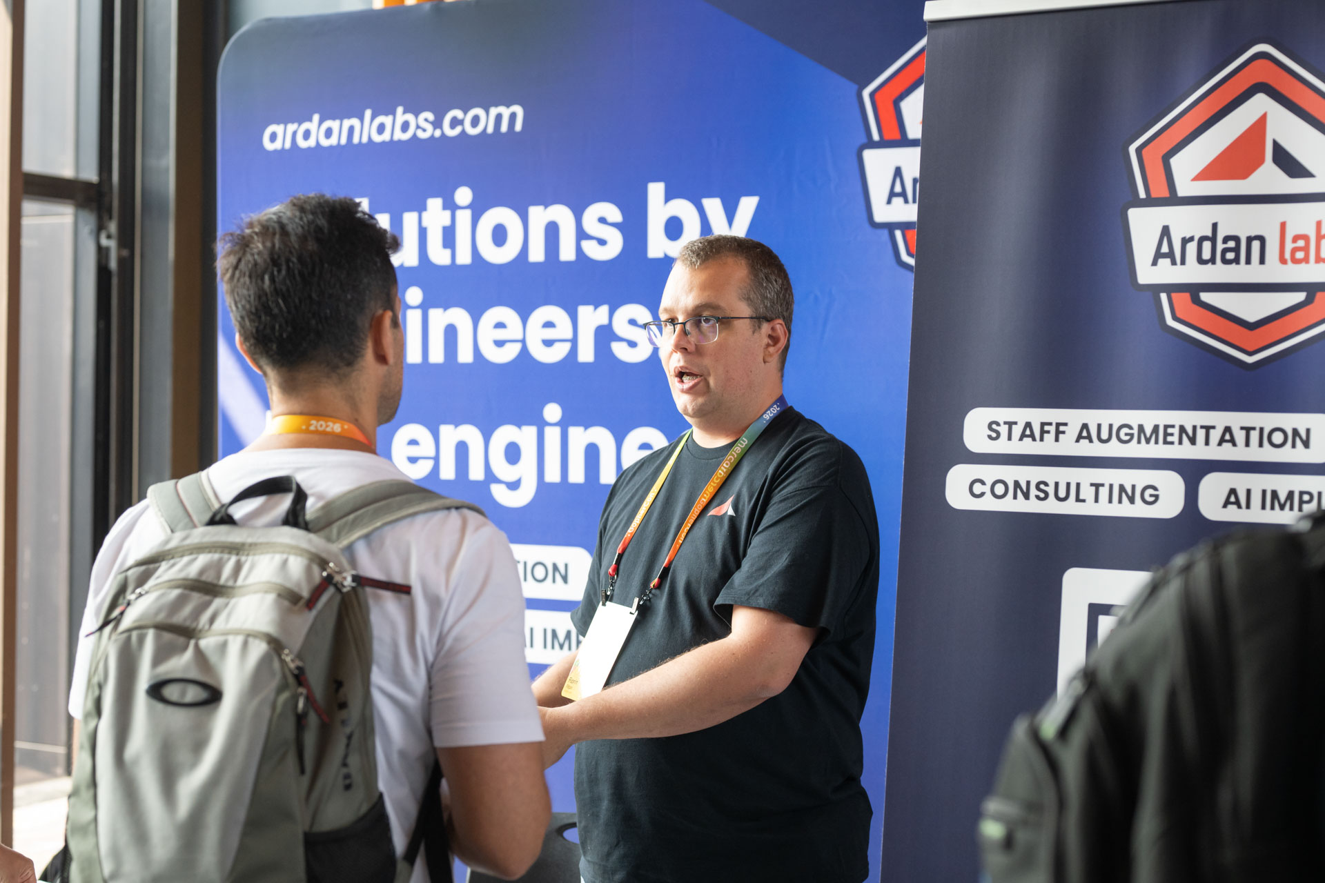 GopherCon US 2026 — Florin Pățan talking with an attendee at the Ardan Labs booth.