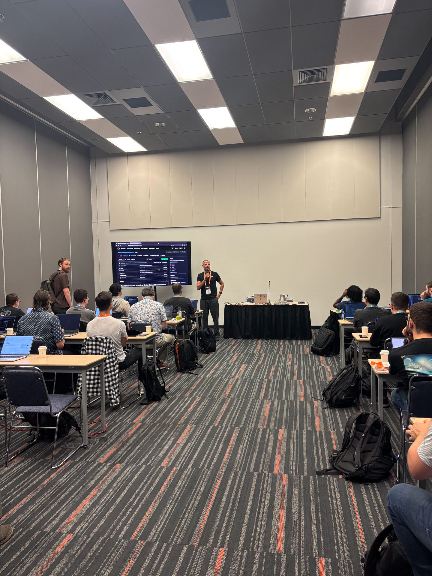 RustConf 2026 — MJ opening the actor-based concurrency workshop for a room of Rust developers.