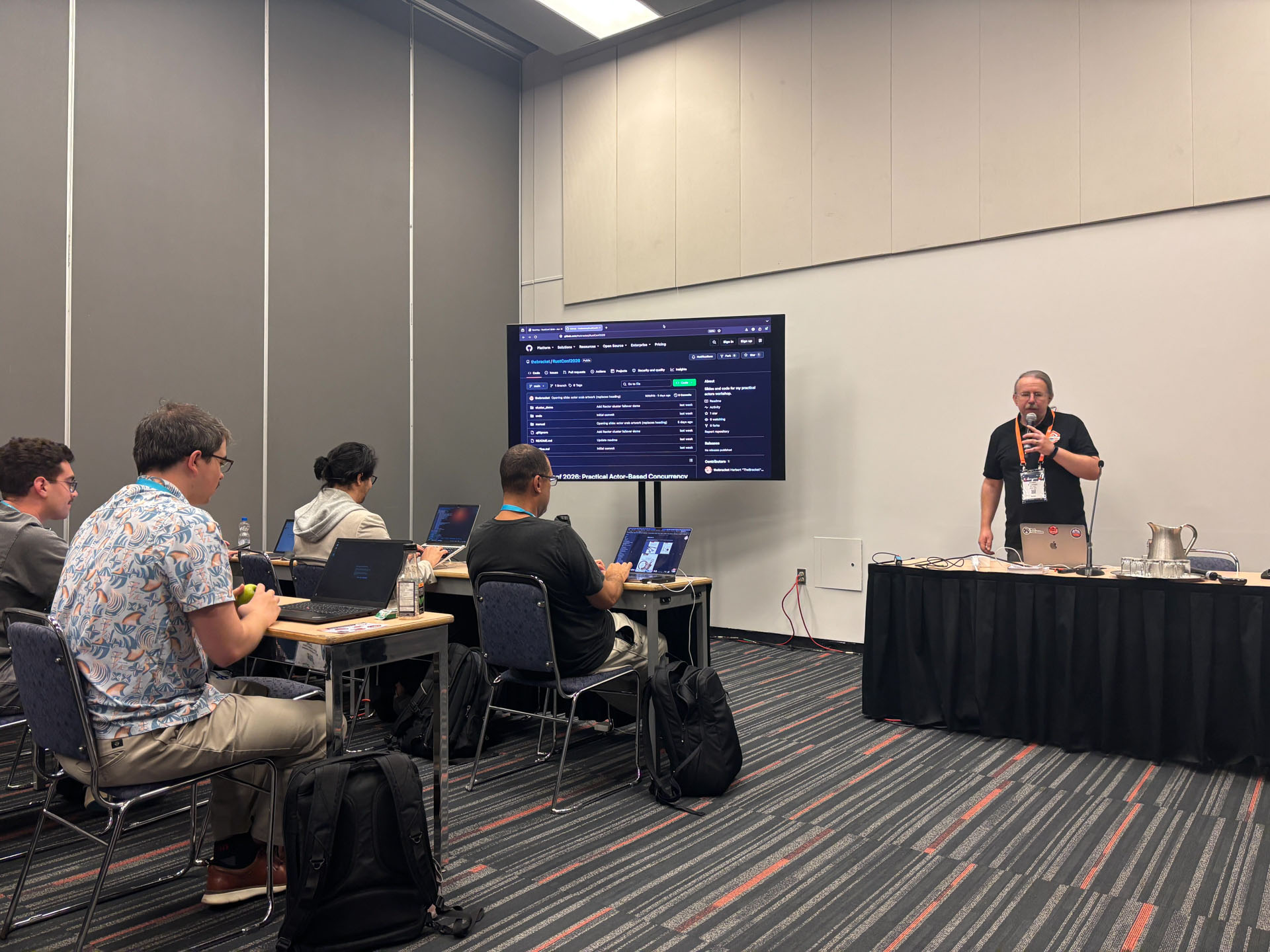 RustConf 2026 — Herbert Wolverson presenting the workshop agenda at the front of the room.