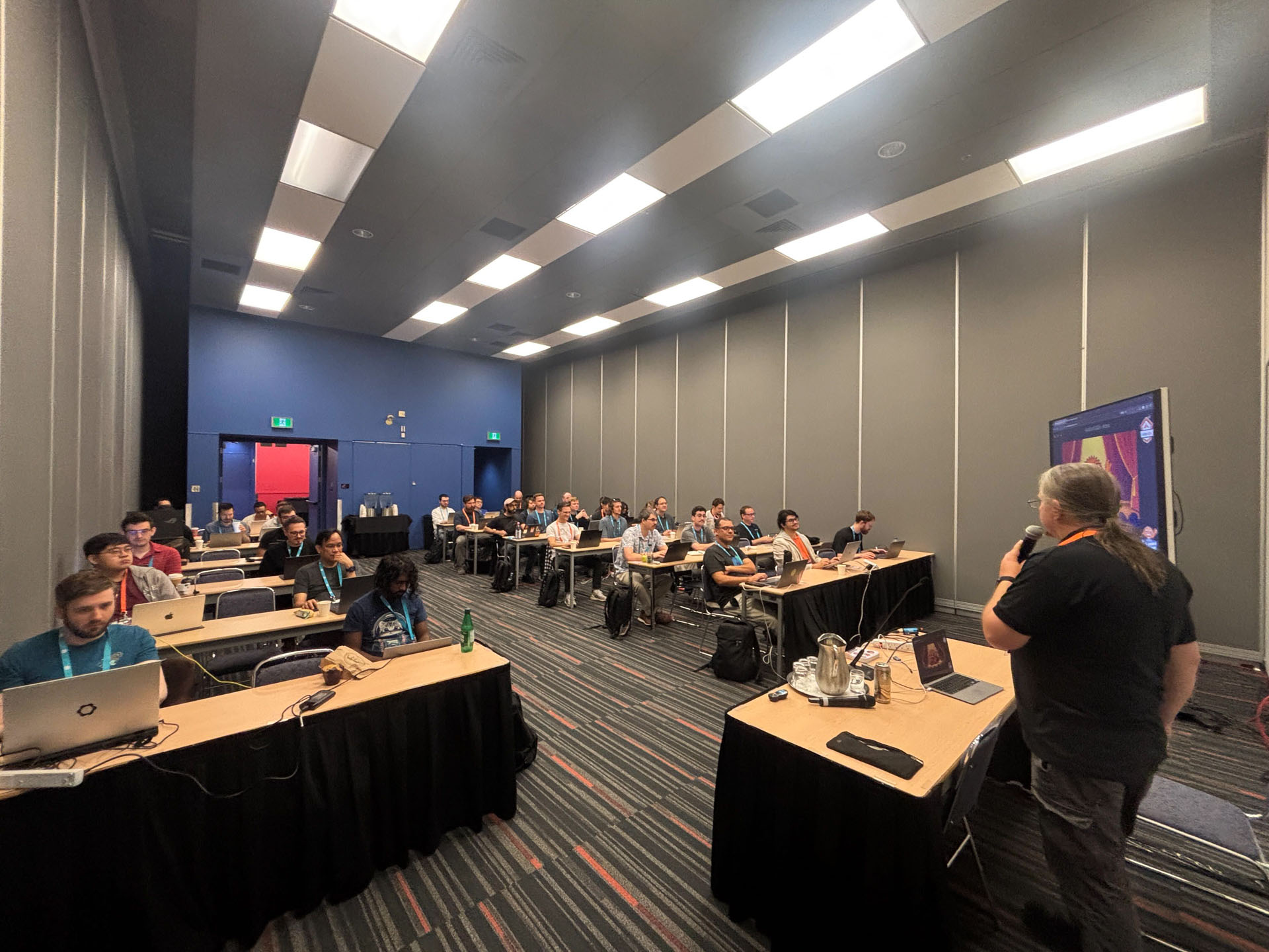 RustConf 2026 — Herbert Wolverson addressing a full classroom of Rust developers.