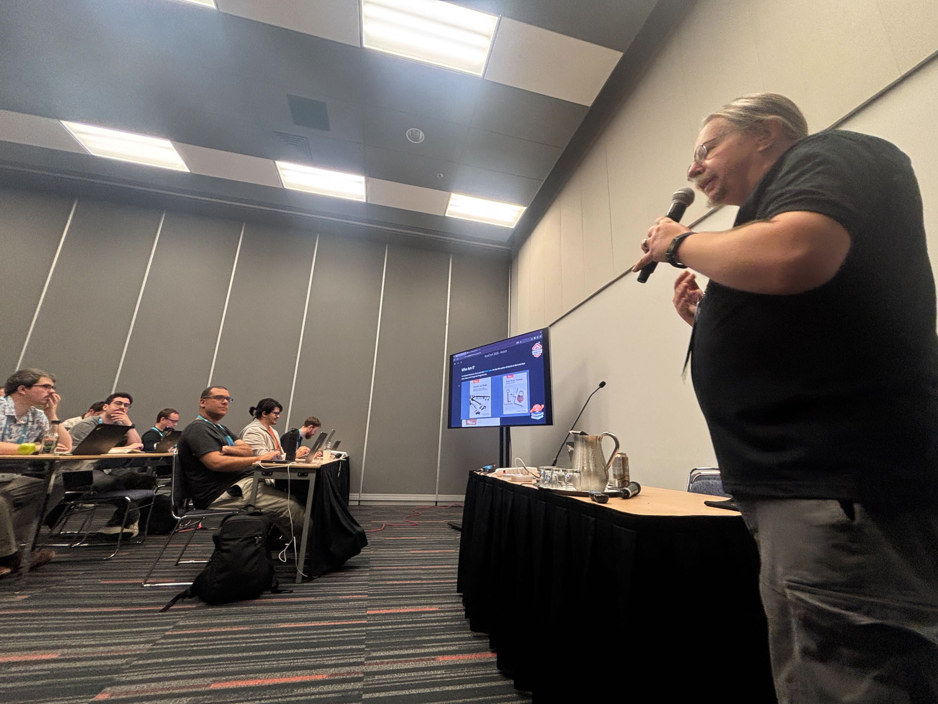 RustConf 2026 — Herbert Wolverson explaining an actor pattern with a microphone in hand.