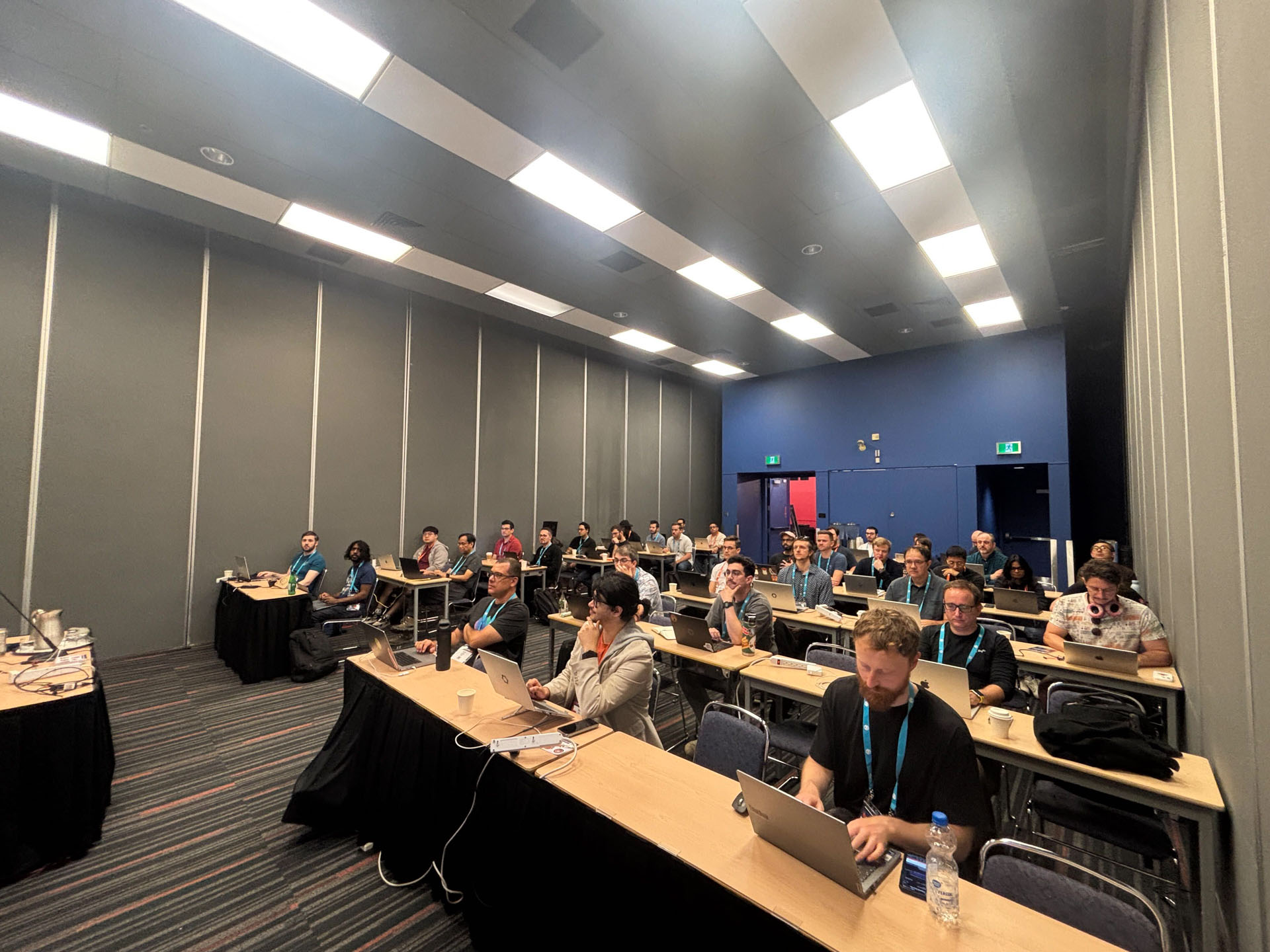 RustConf 2026 — Rust developers coding along at long tables during the workshop.