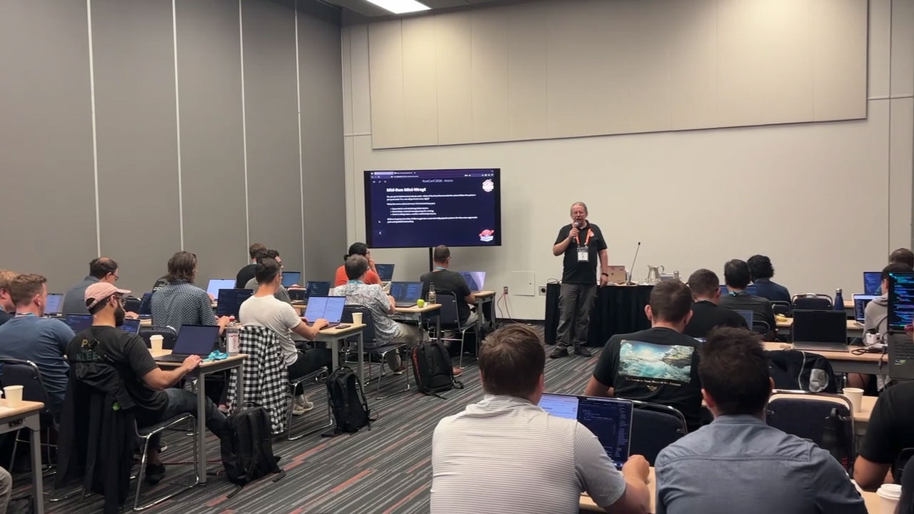 RustConf 2026 — Herbert Wolverson presenting while developers work through the exercises.