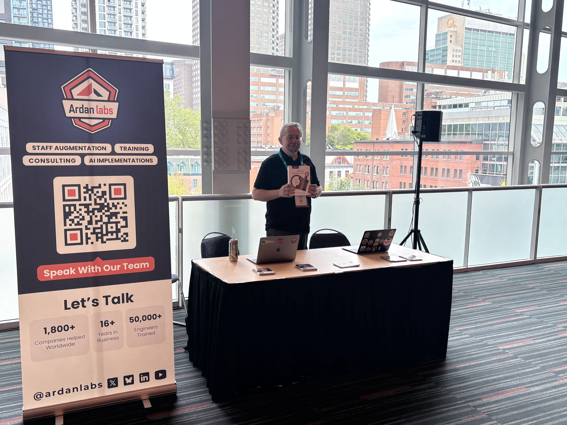RustConf 2026 — Herbert Wolverson holding up a book at the Ardan Labs sponsor booth.