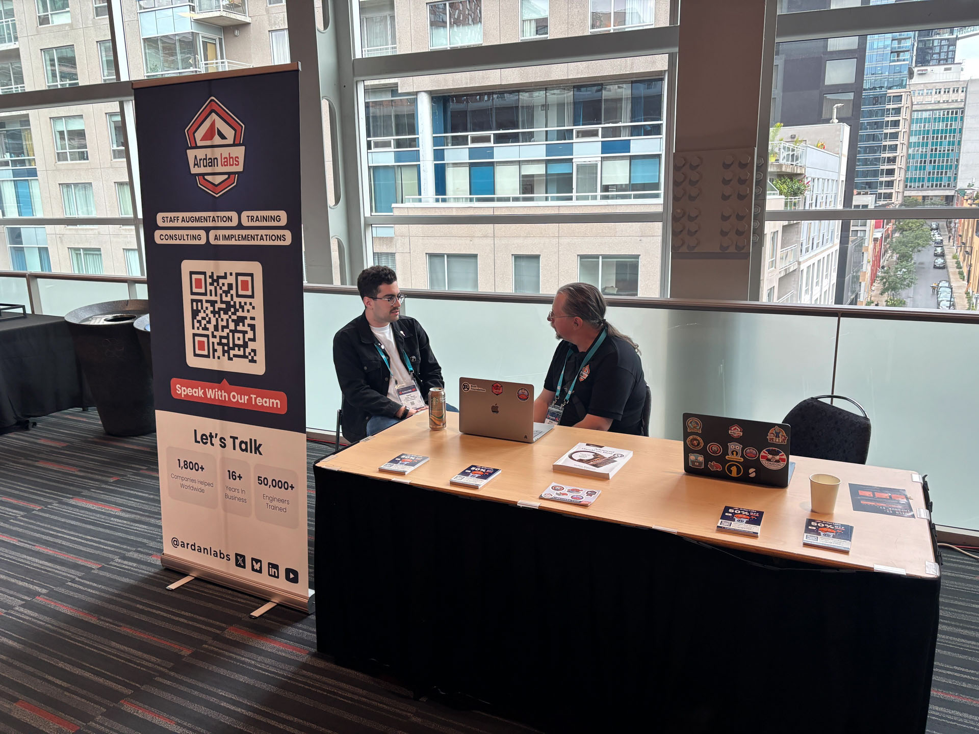 RustConf 2026 — Herbert Wolverson talking Rust training with an attendee at the Ardan Labs booth.