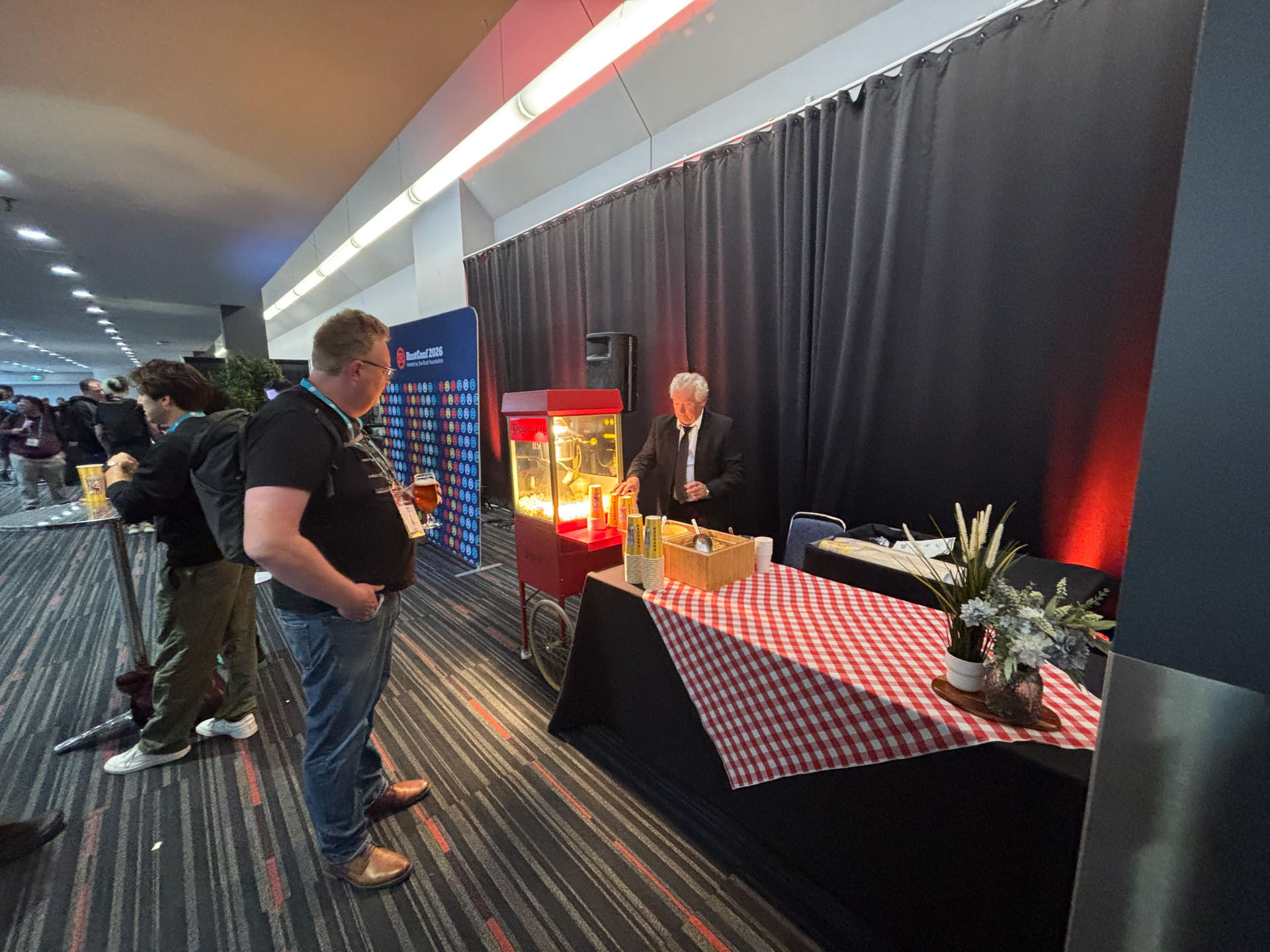 RustConf 2026 — attendees lining up at the popcorn cart during the reception.