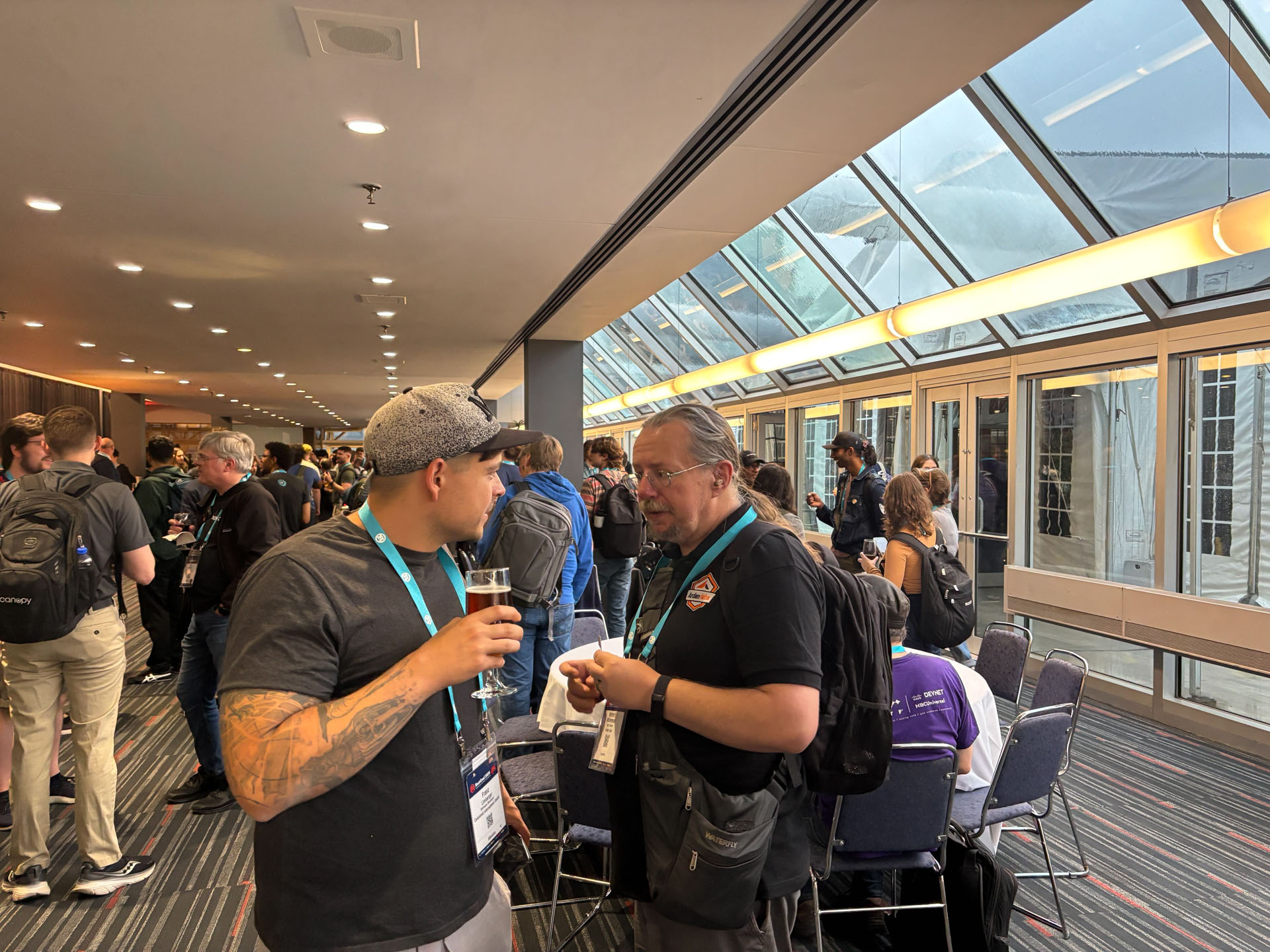 RustConf 2026 — Herbert Wolverson talking Rust with an attendee at the reception.