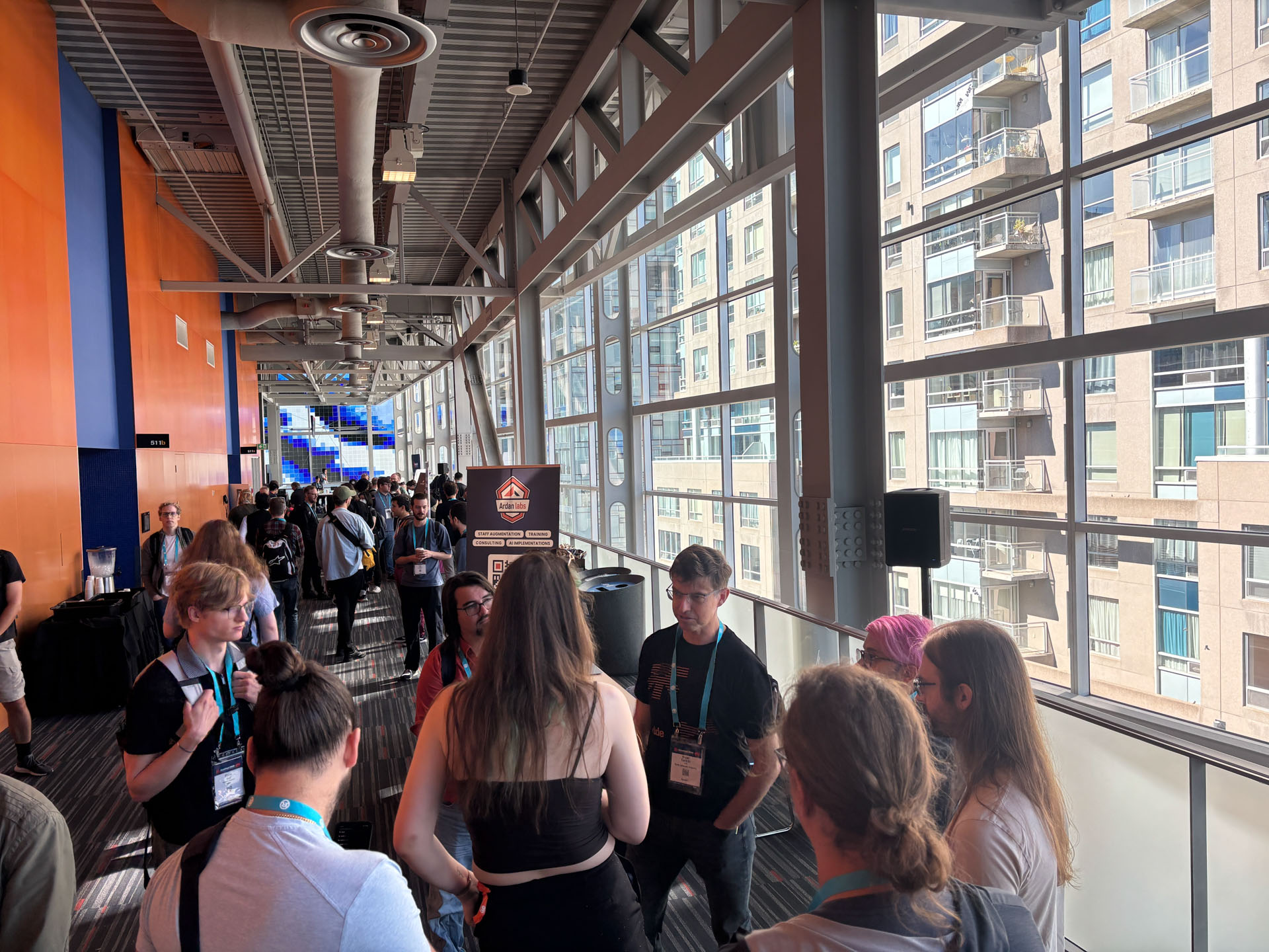 RustConf 2026 — attendees mingling in the sponsor hallway overlooking downtown Montréal.