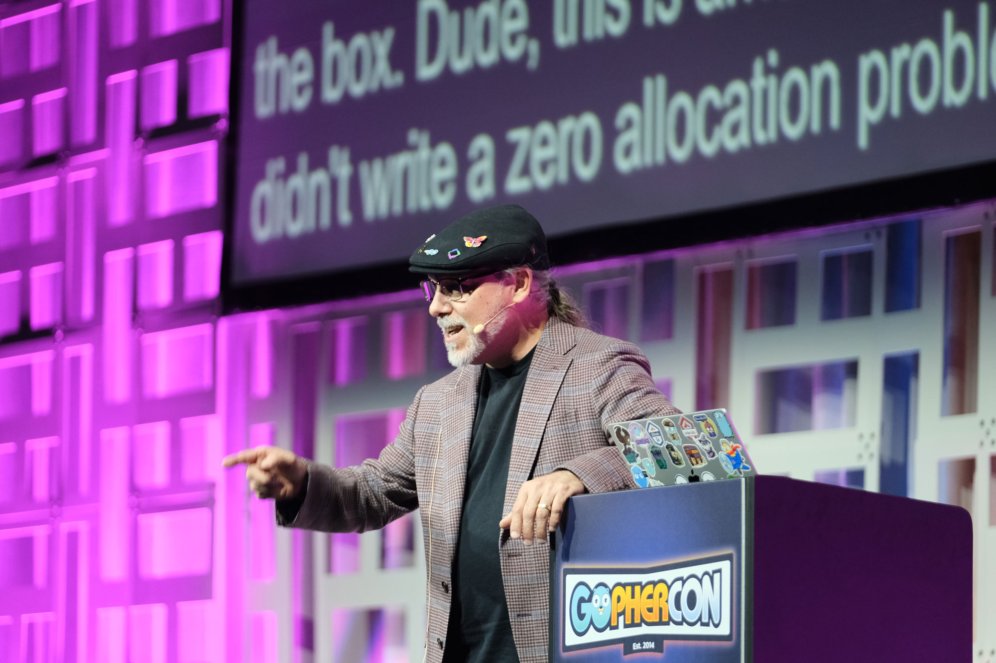 Speaker on stage at GopherCon behind a podium with the GopherCon logo, presenting to the main hall