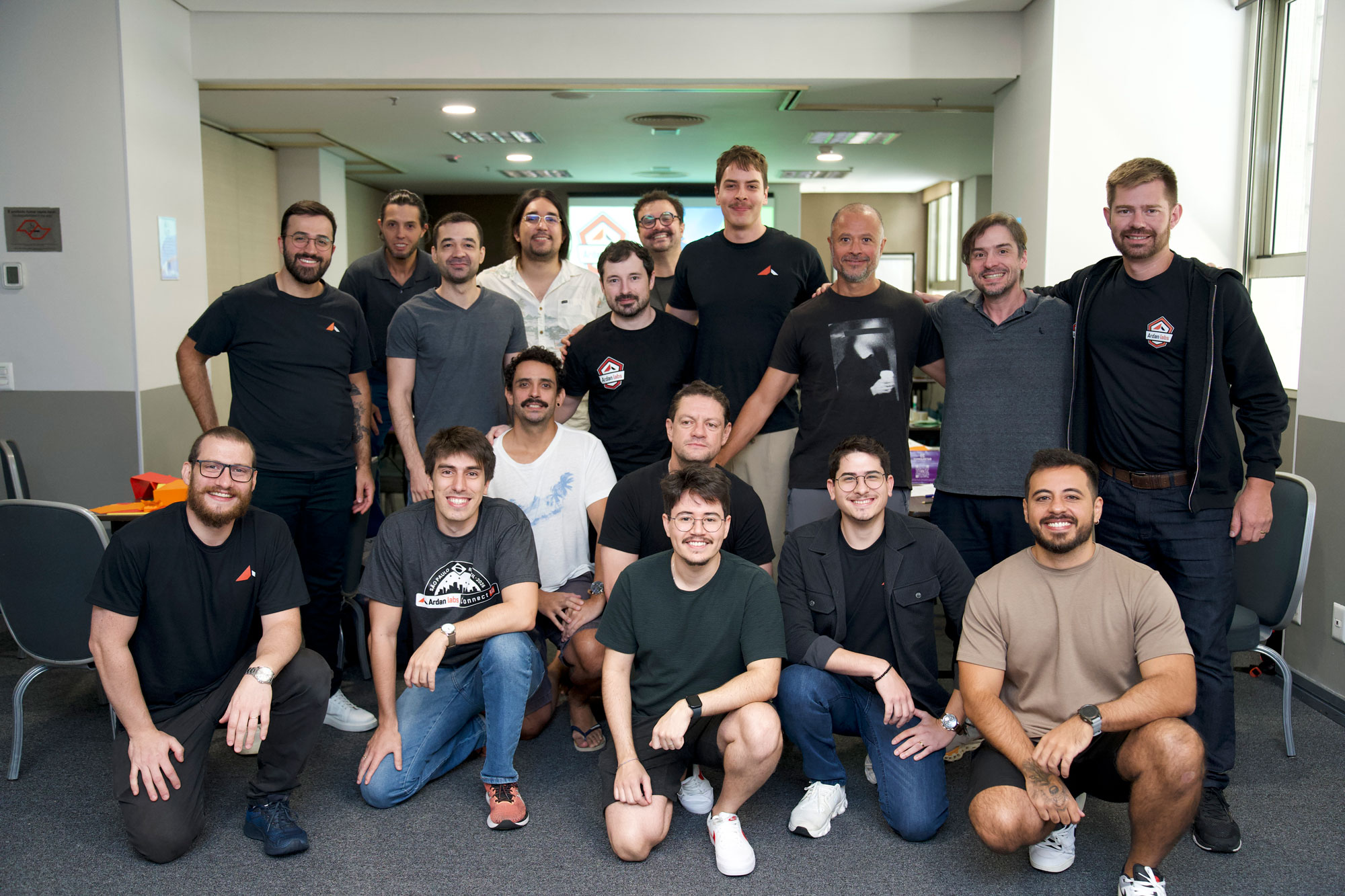Group photo of Ardan Labs staff and community members smiling together indoors