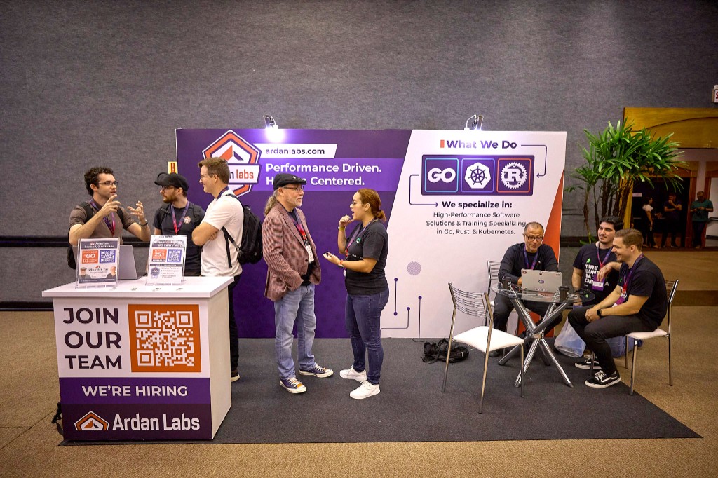 Ardan Labs conference booth with branded backdrop, team members meeting attendees on the expo floor