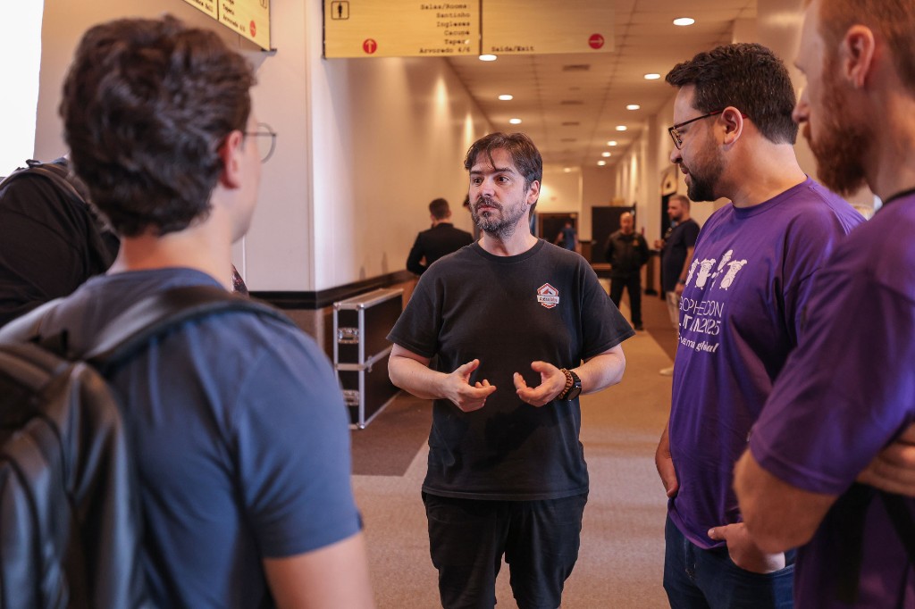 Attendees chatting in a hallway between talks at GopherCon